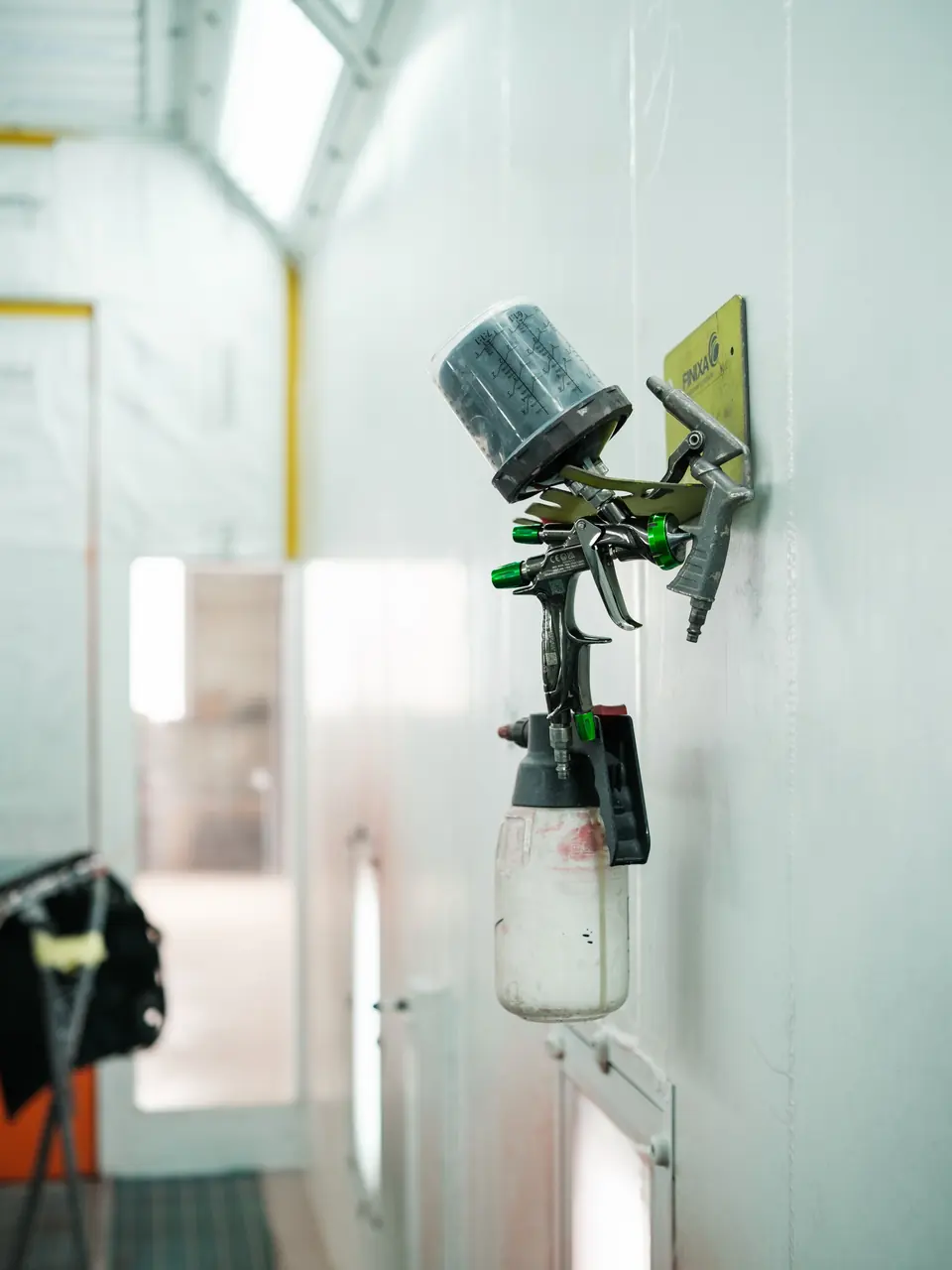 Un pistolet de peinture accroché au mur de la cabine